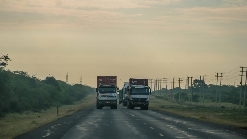Freight truck driving across a major highway route of the Kenya China Highway Project.
